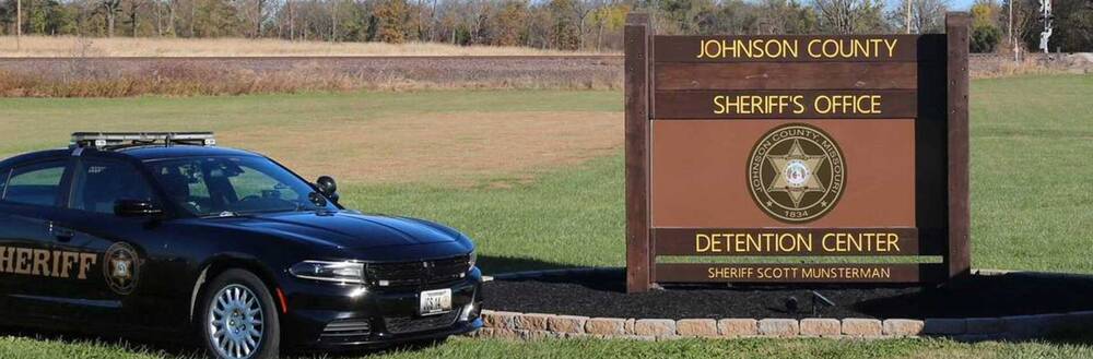 Sheriff's office and detention center sign with patrol car
